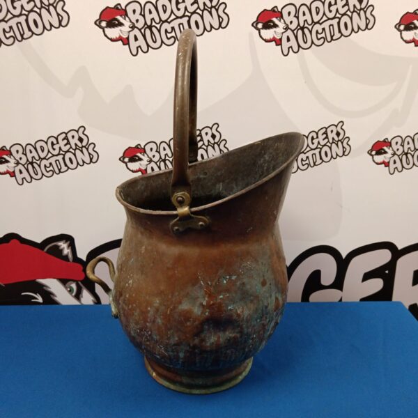 Antique copper coal scuttle with brass handle and helmet shape.