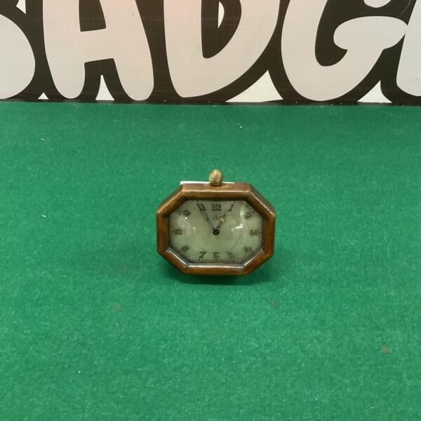 Antique mahogany clock with Roman numerals and a shaped case.