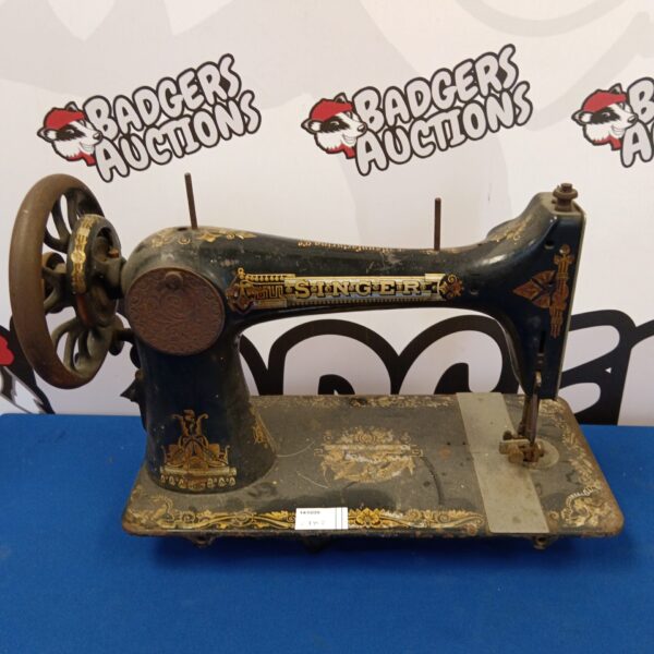 Antique Singer sewing machine with decorative cast iron frame.