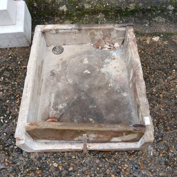 Weathered antique stone trough sink awaiting restoration.