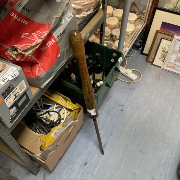 Antique wood turning tool with red packaging in background.