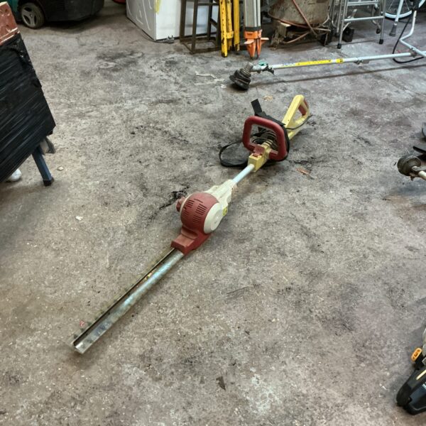 Long reach electric hedge cutter for garden trimming.