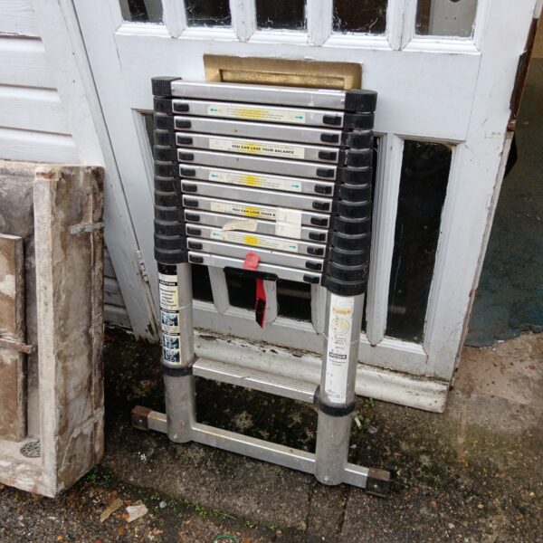 Silver extending aluminium ladder leaning against a wall.