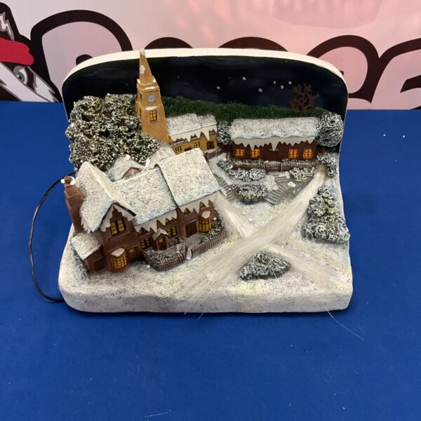 Illuminated fibre optic village scene with twinkling lights and snow.