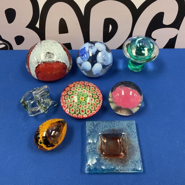 Colorful glass paperweight collection on a patterned background.