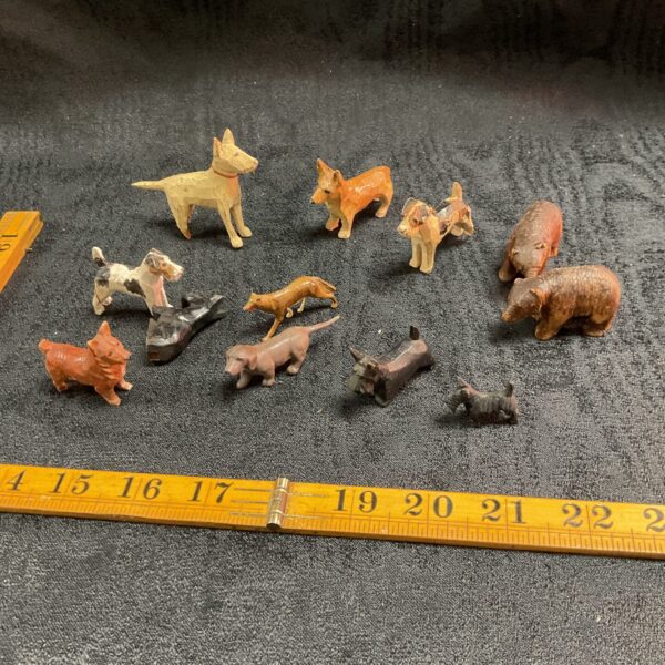 Collection of vintage hand-carved wooden animals, including dogs and bears.