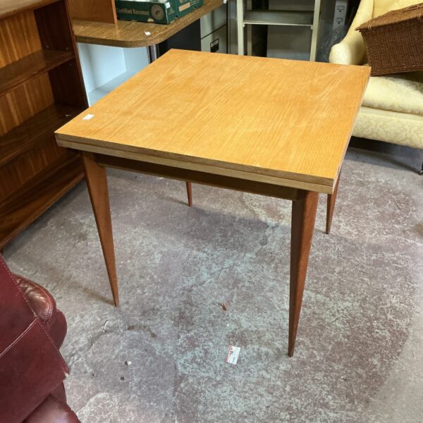 Mid-century light wood extending dining table with tapered legs.