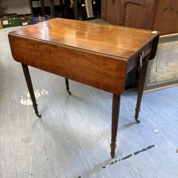 Antique 19th-century mahogany drop leaf table with casters.