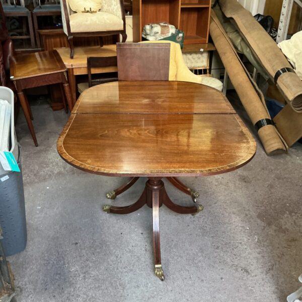 Antique mahogany extending dining table with carved legs.