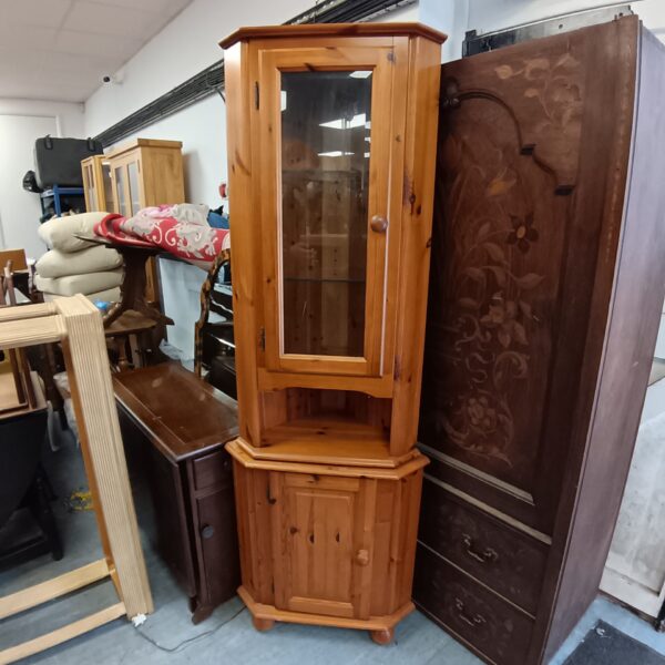 Tall pine corner display cabinet with glass front.