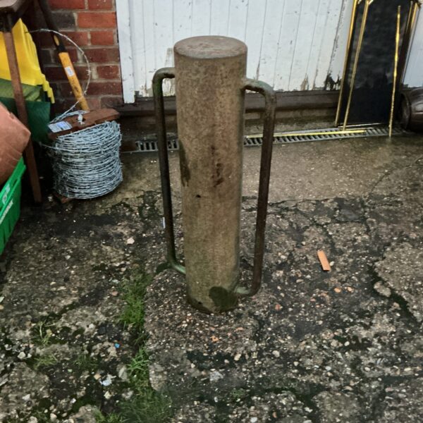 Rusty metal post hammer for driving fence posts.