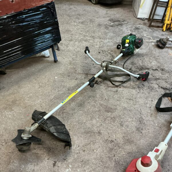 Used Qualcast petrol strimmer showing side view and engine.