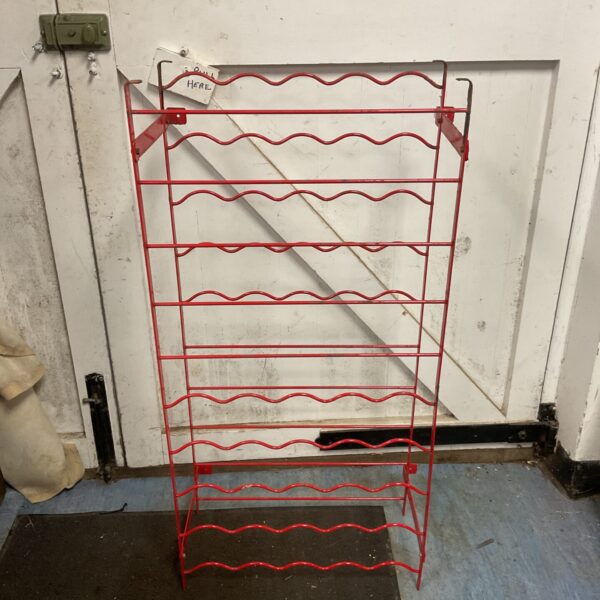 Vintage red metal wine rack for bottle storage.