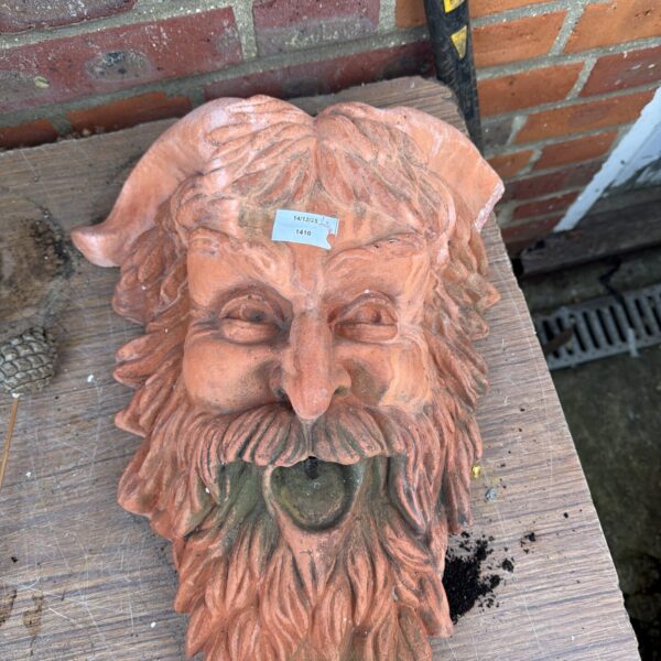 Detailed vintage terracotta mask for garden or architectural decor.