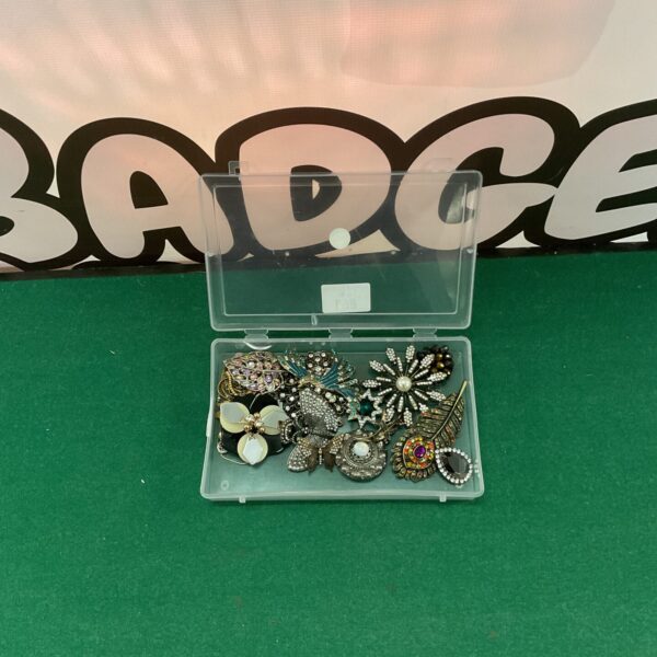 Vintage brooch lot with colourful enamel pins and jewellery.