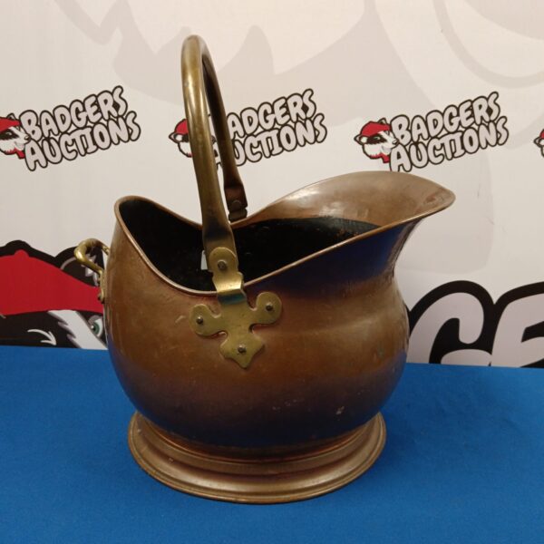Vintage copper coal scuttle with brass handle and curved design.