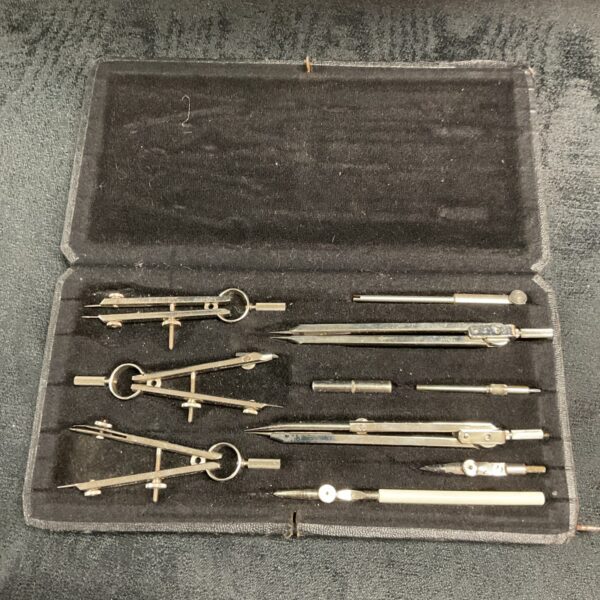 Vintage German drafting compass set with geometric tools.