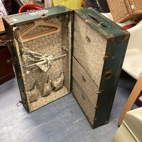 Open vintage green travel trunk with hanging rail inside.
