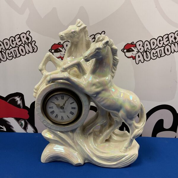 Vintage Mercedes clock with porcelain rearing horses sculpture.