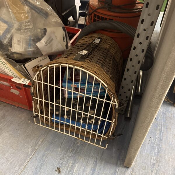 Vintage wicker pet carry basket with blankets inside.