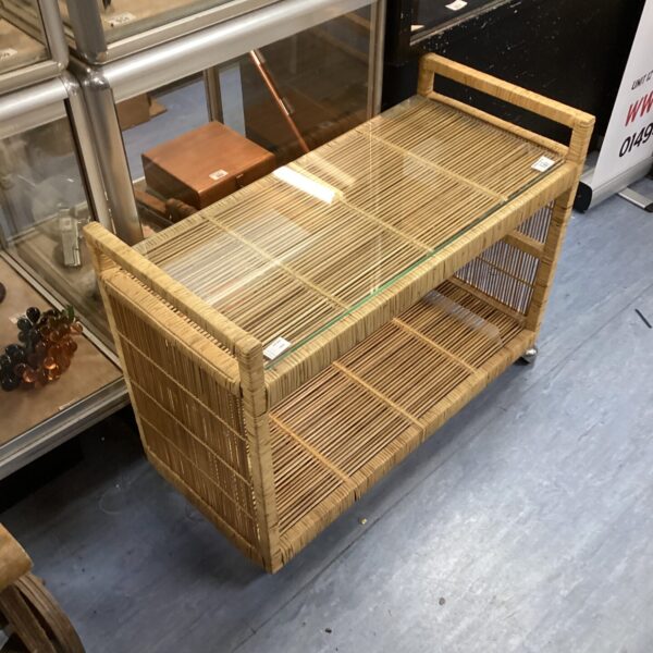 Vintage rattan hostess trolley with glass tops, ideal for serving drinks.