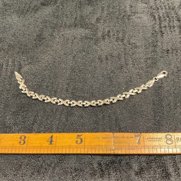 Close-up of a 925 silver X link bracelet.