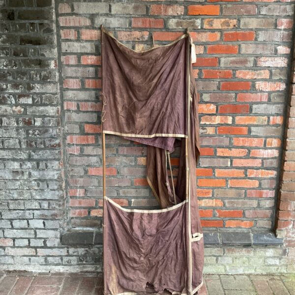Antique 1913 box kite against brick wall