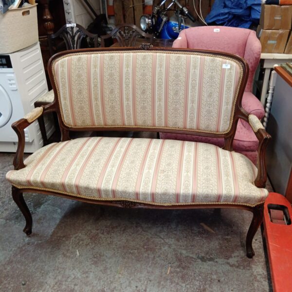 Antique French boudoir sofa with striped upholstery and carved wood.