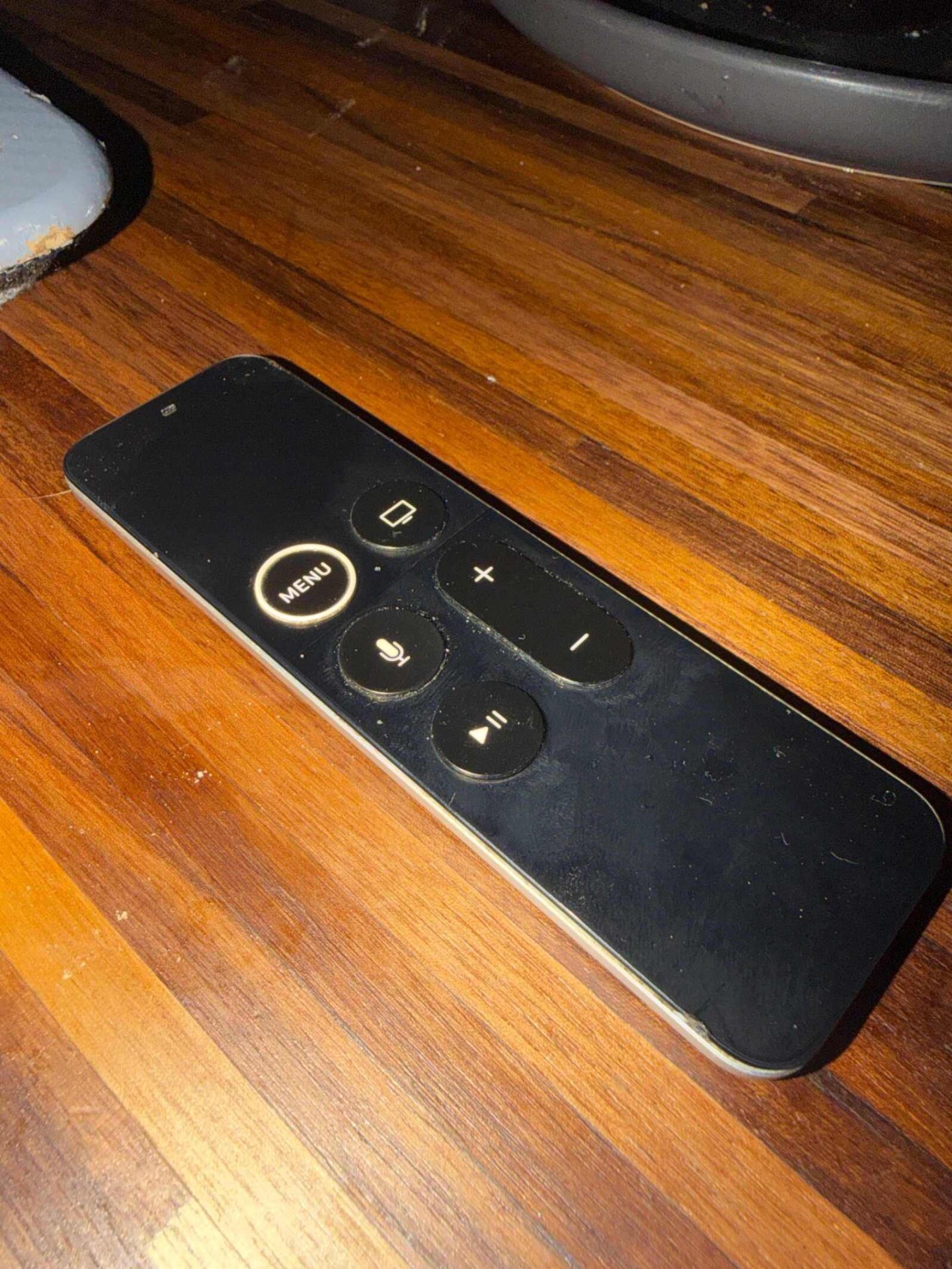 Silver Apple Remote for Apple TV, minimalist design.