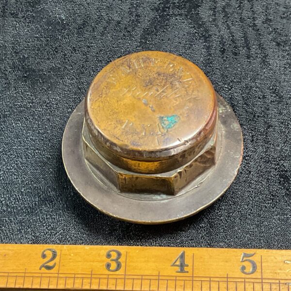 Antique brass cart hub cap with "farmeve Rye" marking.