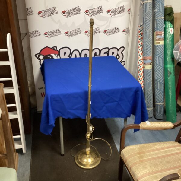 Vintage brass standard lamp draped with blue cloth.