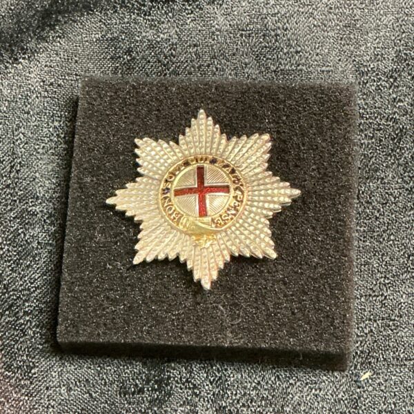 Detailed brass Coldstream Guards cap badge with Garter star.