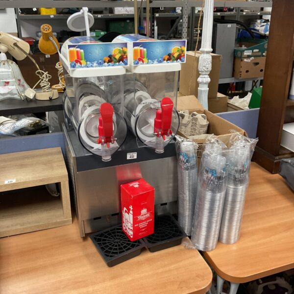 Commercial slush machine with disposable cups for frozen drinks.