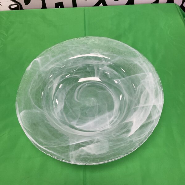 White swirl Costa Boda art glass bowl on green background.