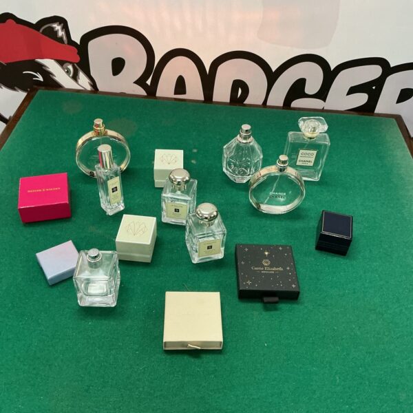 Collection of empty designer perfume bottles and jewellery cases for display.