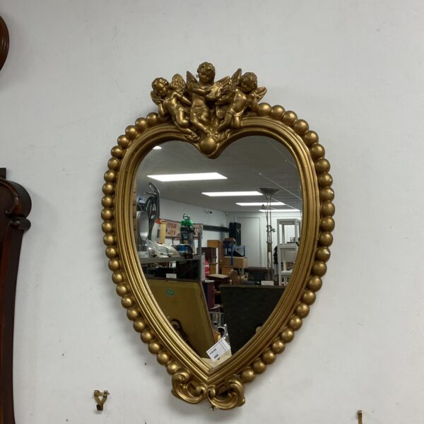 Ornate French style gilt mirror with cherub details.