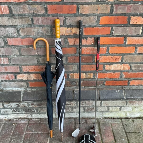 Golf umbrellas and iron set for outdoor recreation.
