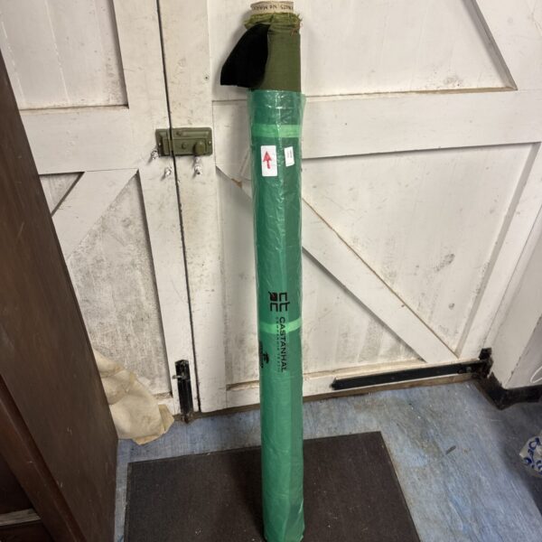 Side view of a green velour fabric roll against a white door.