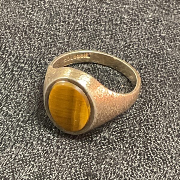Close-up of a vintage men's tiger eye ring in gold and silver.