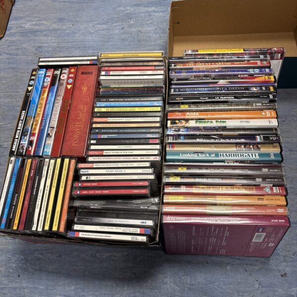 Overview of a mixed lot of DVDs and CDs for sale.