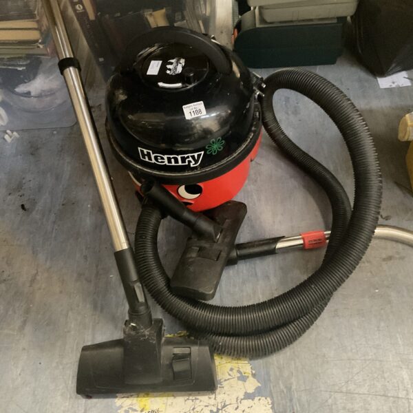 Red Numatic Henry cylinder vacuum cleaner with pole attachment.