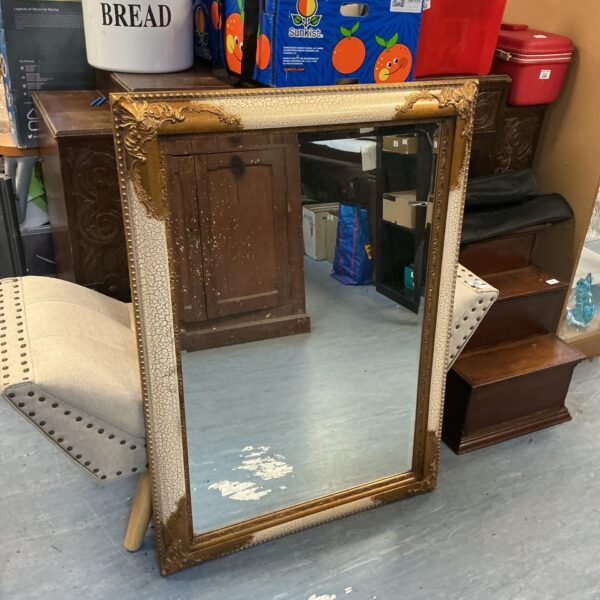 Large ornate framed mirror with a gold coloured frame.