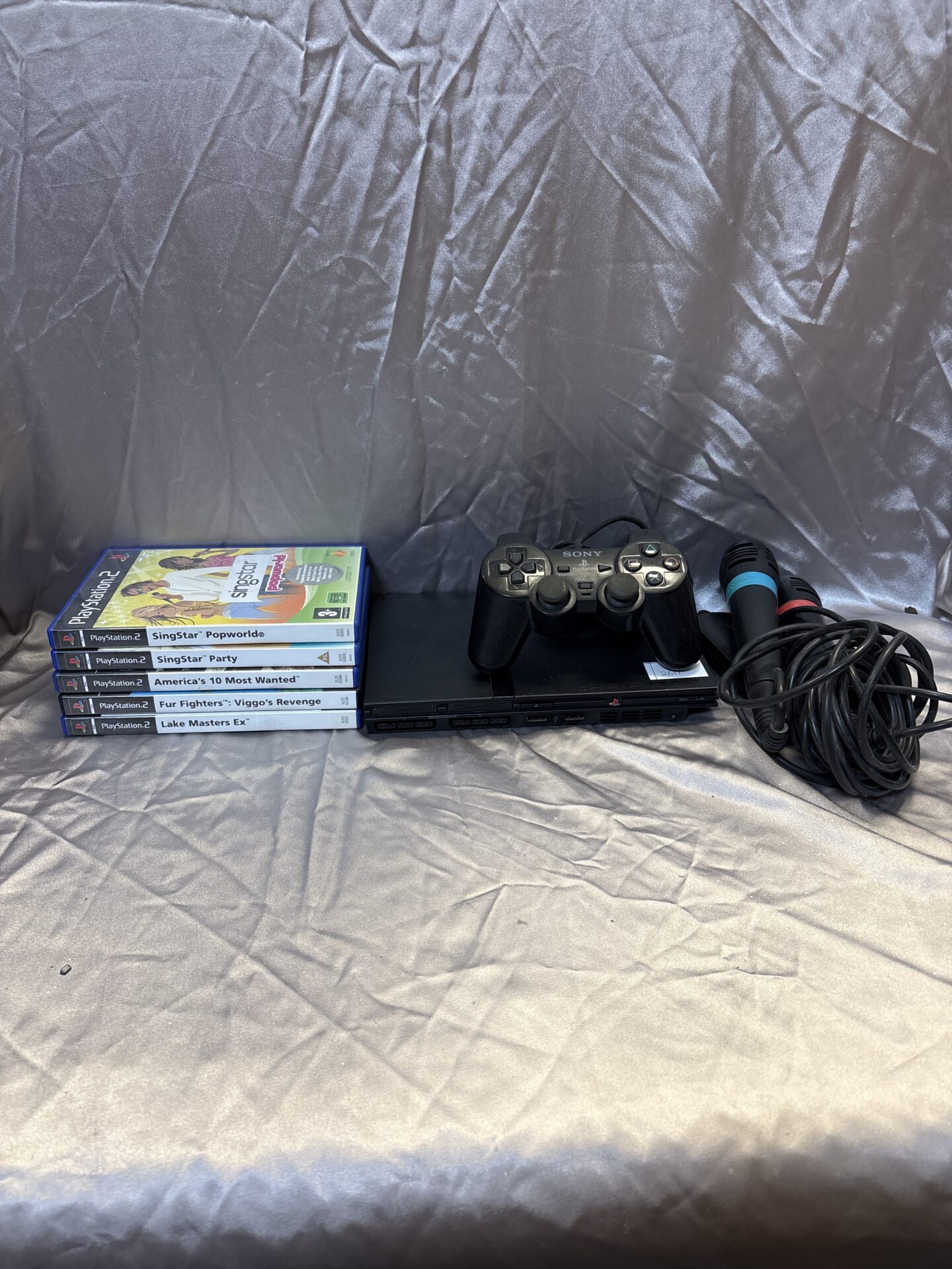 219 Sony PlayStation two slim with games controller and sing star accessories