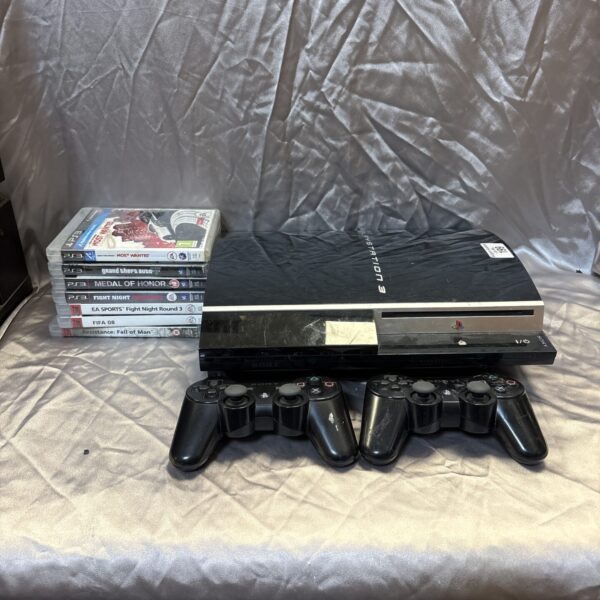 Black Sony PlayStation 3 console with games and controllers.