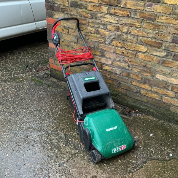 Vintage Qualcast Elan lawn rake for garden maintenance.