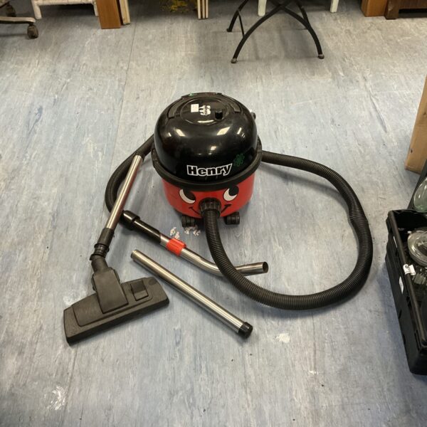 Red Numatic Henry hoover with pole extender and carpet attachment.
