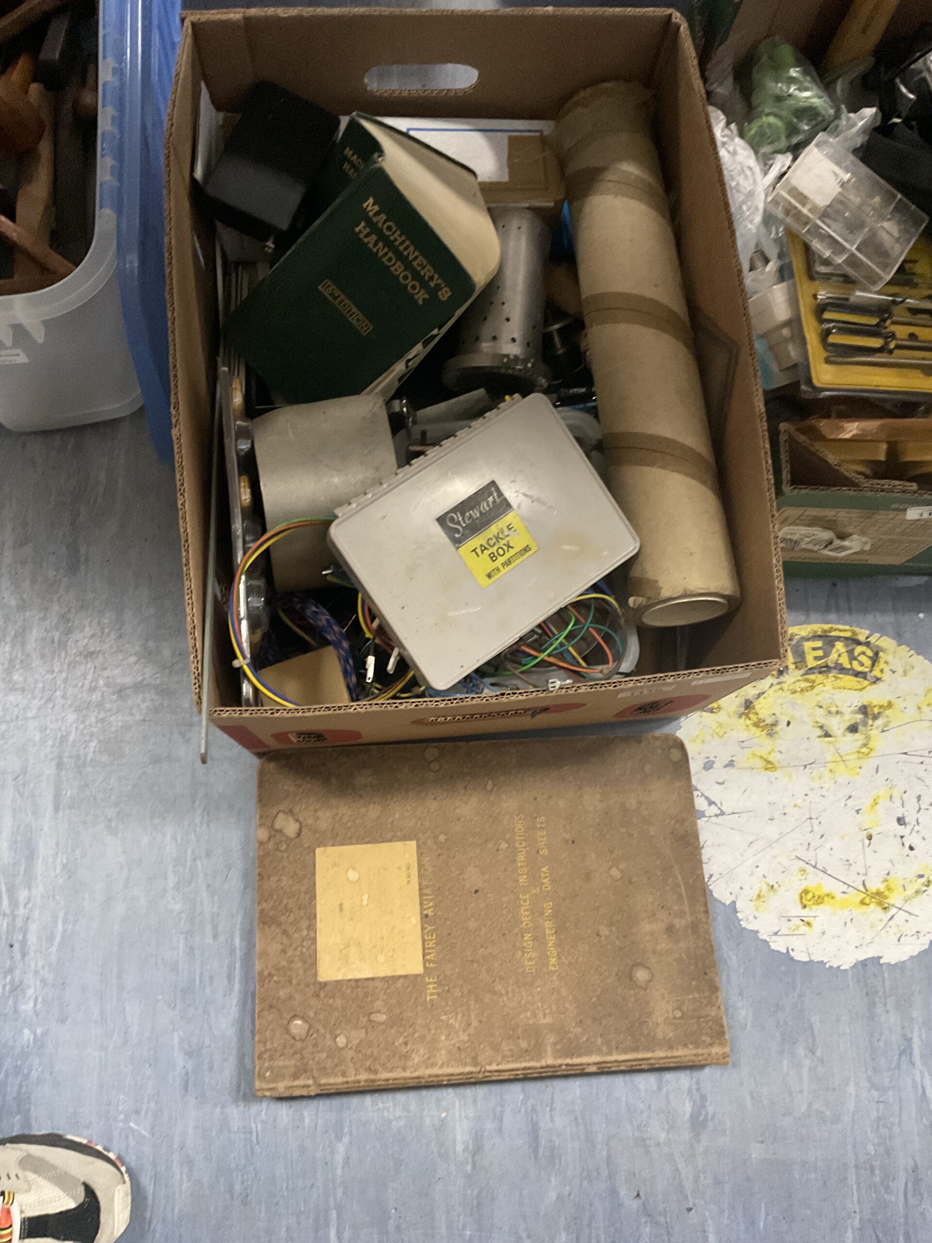 1115 Box of mixed shed clearance items including machinery handbook and tacklebox
