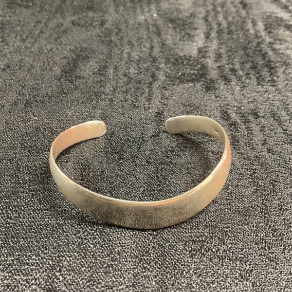Elegant silver curved open bracelet, minimalist jewellery design.