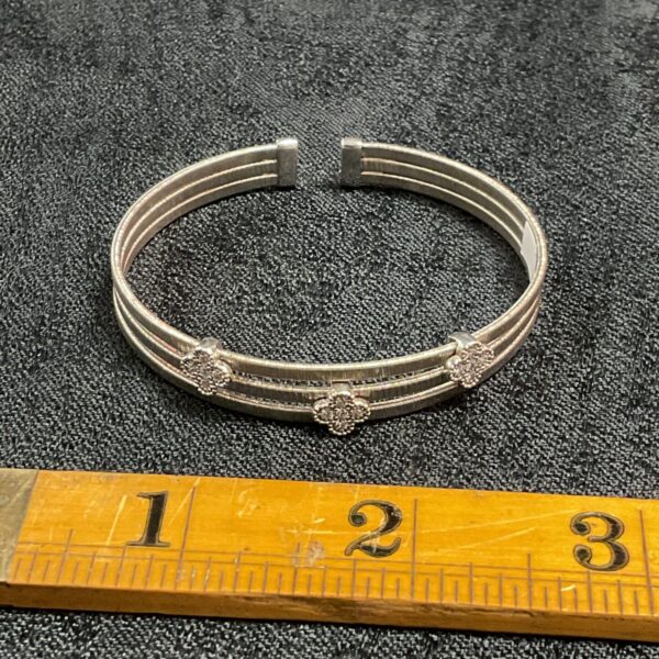 Hallmarked silver bracelet with three flower motifs.