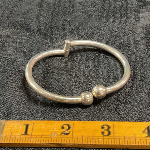 Silver hinged bracelet with ball ends, classic jewellery piece.